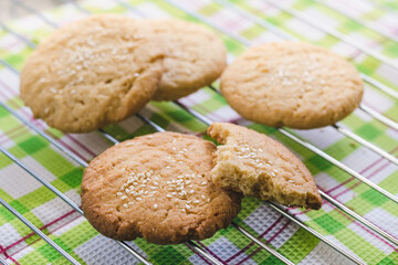 Homemade delicious round shortbread cookies with sesame seeds on a wire rack