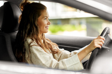 woman or female driver driving car in city