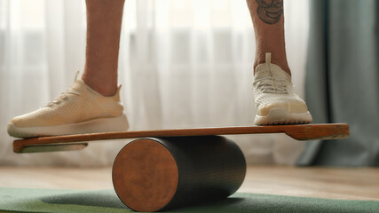 Balance board with man in trainers standing on it