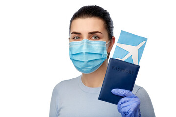 young woman in mask with air ticket and passport