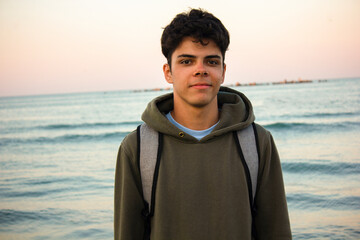 Portrait of teenage boy with a sea in the background during sunset © Ceban
