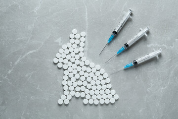 Rabbit figure of pills and syringes on light marble table, flat lay. Stop animal tests