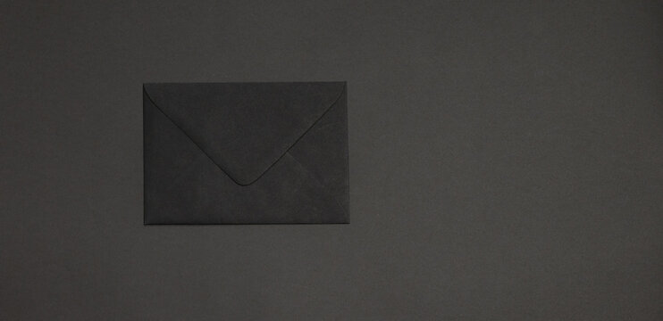 Black envelope on dark background. Template branding mockup. Copy space for text.