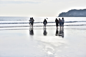 鎌倉由比ヶ浜海岸で遊ぶ若い女性たちのシルエット