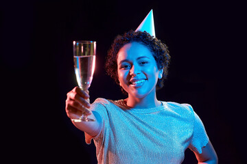 african woman in party cap with glass of champagne © Syda Productions