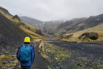 Person walking towards the black mountains of iceland.