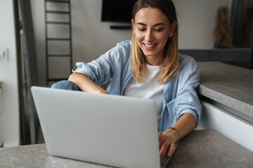 Happy beautiful young woman using laptop computer