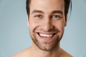 Fototapeta premium Close up of a smiling brunette shirtless man with stubble