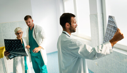 Obraz premium Group of doctor looking at ct scan at hospital to make diagnosis