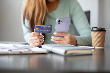 Close up woman hand using credit card and smartphone laptop for buying online shopping