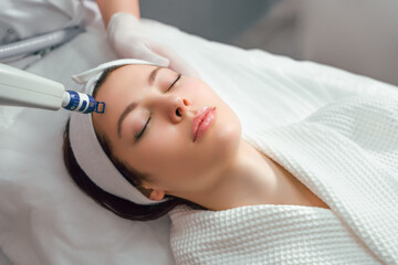 Obraz na płótnie Canvas A woman receives laser treatment of the face in a cosmetology clinic, a concept of skin rejuvenation is being developed. laser peeling