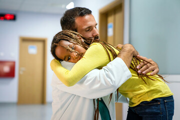 Doctor having conversation with sad little girl at the hospital. Doctor consoling child