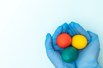 Easter card 2021. Hands in protective medical gloves holding colorful Easter eggs on a white background. Happy safe Easter concept. New norma concept