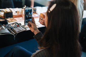 Brunette woman taking selfie photo on cellphone in beauty salon