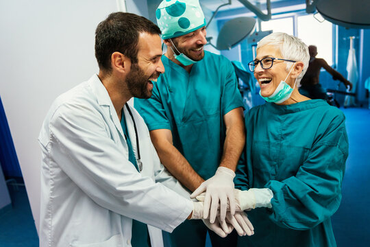 Smiling doctor giving high five after successful surgery. Healthcare, success, doctor concept