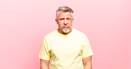 old senior man looking puzzled and confused, biting lip with a nervous gesture, not knowing the...