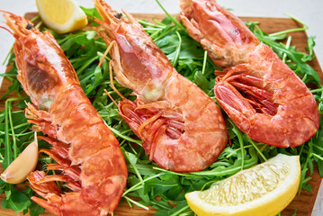 Red raw prawns, close up. Fresh shrimps with lemon and rucola. Seafood background