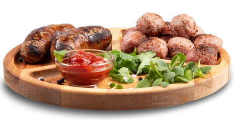 Fried sausages and meat balls with sauce and herbs on a wooden plate. White background.