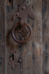 Close up of a decorative medieval iron door knocker  en key hole