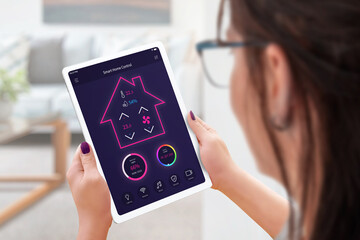 Woman with tablet controls a smart house, temperature, humidity, lighting and security