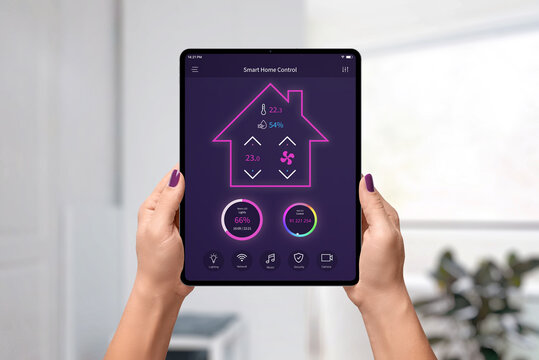 Smart home control app on tablet in woman hands. Home interior in background