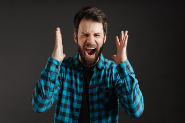 Bearded white angry man screaming at camera with hands up