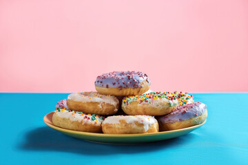 Love at first bite. Different colourful round glazed donuts with sprinkles on the plate
