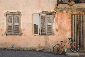 Fototapeta na wymiar Old idyllic house with orange bike in front of it in a city in the Provence in France