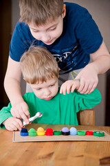 Naklejka premium Plastic bottle caps worm. Put correct color pom poms in centipede caterpillar. 5 minute carfts. DIY children home activity. Early education, fine motoric skills.