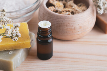 Natural spa products on wooden table. Essential aroma oil, handmade soap and other accessories. Home spa, aromatherapy, wellness concept. Close up
