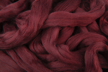 Pretty marroon red merino wool lying in loose stings ready to be used