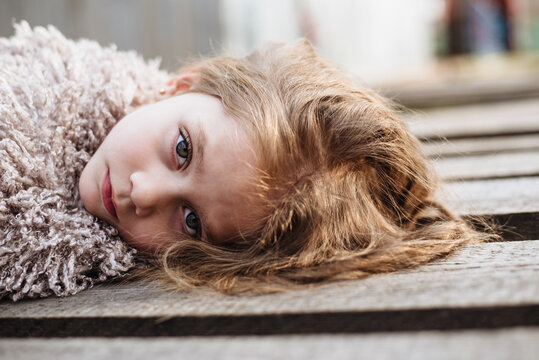 Portrait of a beautiful teen girl with sad eyes. An upset child is lying on the floor. Childhood depression.