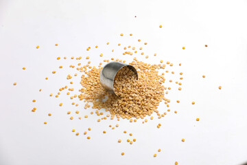 Unpolished Pigeon pea also known as toor dal in a metal bowl. Isolated on white background.