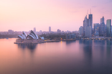 Beautiful golden sunrise or sunset light over cityscape view from the Harbour Bridge over Sydney Harbour skyline and opera house in NSW, Australia.