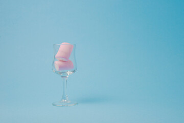Single pink marshmallow shot on a blue background.