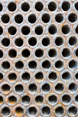 Pipe tube sheet or plate of heat exchanger or boiler closeup corrosion texture background with insoluble hard mineral deposits salts scale and corrosion. Trypophobia concept.