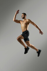 Strong handsome sportsman in sportswear warming up in the room indoors