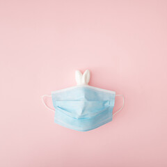 A blue surgical face mask covers the white Easter bunny.