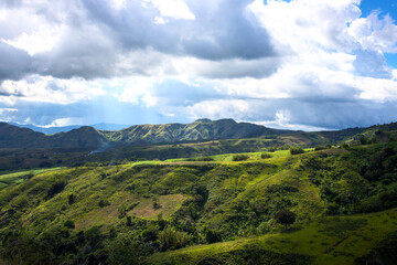 Green field and mountain under sunlight spectacular landscape. Spectacular mountain view. Rural land scenery. Summer travel hiking in green hills. Untouched nature parkland. Volcanic island relief