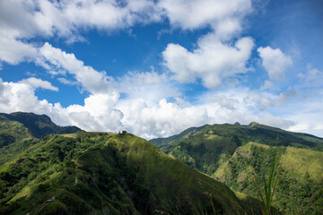 Green mountain distant peak under blue sky optimistic landscape. Rural land scenery. Summer travel hiking in green hills. Untouched nature parkland. Volcanic island relief