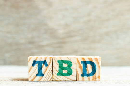 Alphabet letter block in word TBD (Abbreviation of to be defined, discussed, determined, decided, deleted or declared) on wood background