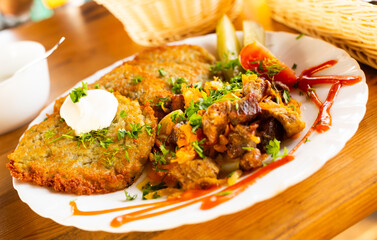 belarusian draniki with grilled beef dish in a restaurant