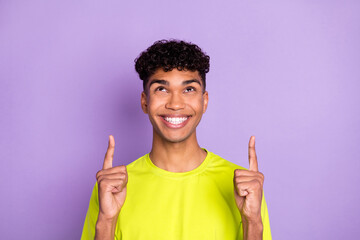 Photo of young african guy happy smile look indicate fingers empty space ad promo select suggest isolated over violet color background