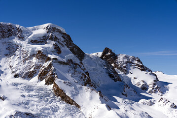 Snow capped mountains, snowfields and glaciers at Zermatt, Switzerland, seen from Gornergrat railway station. Photo taken March 23rd, 2021.