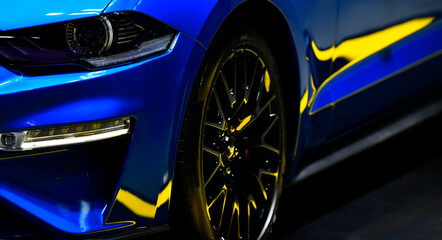 Obraz na płótnie Canvas Front headlights of blue modern car on black background