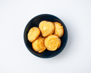 Creative composition of fresh baked muffins in blue ceramic bowl, heart and rose shape, food concept, flat lay, top view