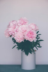 Fresh spring bouquet of pink peonies in full bloom in vase, close up. Summer flowers.
