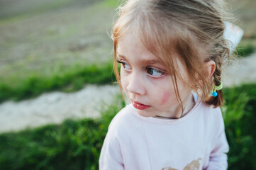 Portrait of adorable blond baby  crying and screaming outdoors. Homeless child. The concept of violence against and abuse of children.