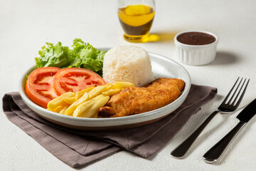 Executive dish with breaded fillet, rice, beans and salad.