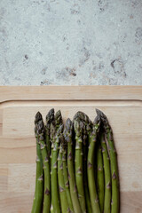 fresh asparagus on wooden board, space for writing
